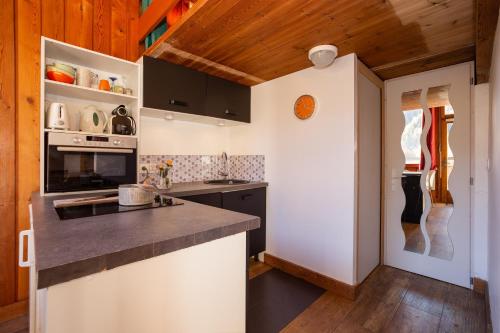 Il comprend une cuisine dotée de plafonds en bois et d'un comptoir. dans l'établissement Résidence Grand Roc - Studio 708 - Happy Rentals, à Chamonix-Mont-Blanc