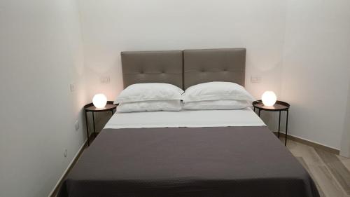 un grande letto con due lampade su due lati di B&B "La Dimora delle Gravine" a Gravina in Puglia