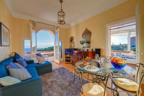 a living room with a blue couch and a table at Villa MonTLilin - Happy Rentals in Villefranche-sur-Mer