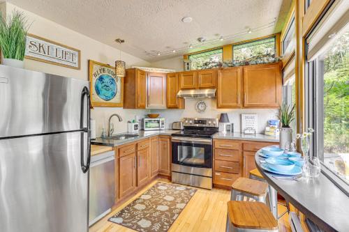 a kitchen with wooden cabinets and a stainless steel refrigerator at Scenic Lead Cabin Steps to Terry Peak Ski Area! in Lead