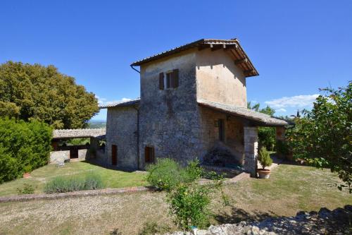 an old stone house on a hill with trees at Il Fortino - Happy Rentals in Monteriggioni