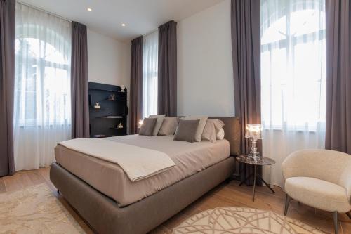 a bedroom with a large bed and a chair at Accomodation Hotel Castello Il Codirosso in Cesate