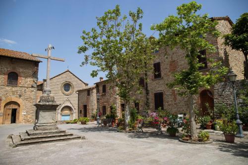 a courtyard of an old stone building with a church at Family Friendly Villa Giulia with pool - Happy Rentals in Lucignano
