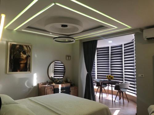 a bedroom with a bed and a table and a mirror at Deluxe Apartment In City Center in Tirana