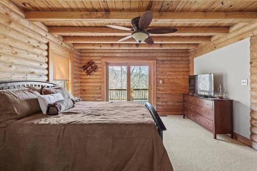 une chambre avec un lit et un ventilateur de plafond dans l'établissement Awesome Log Cabin in Massanutten Resort, à McGaheysville