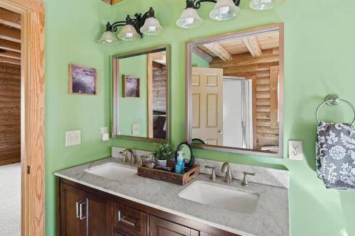 une salle de bain avec deux lavabos et un miroir dans l'établissement Awesome Log Cabin in Massanutten Resort, à McGaheysville