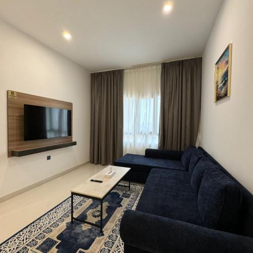 a living room with a couch and a tv at واجهة السعادة للشقق الفندقية in Salalah