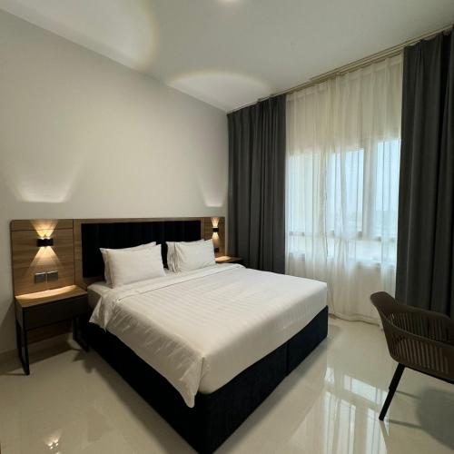 a bedroom with a large bed and a window at واجهة السعادة للشقق الفندقية in Salalah