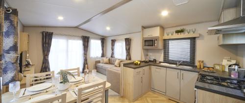 a kitchen and a living room with a couch at Elegant 2 Bed 1 and Half Bath Caravan in Holiday Resort Village in Northampton