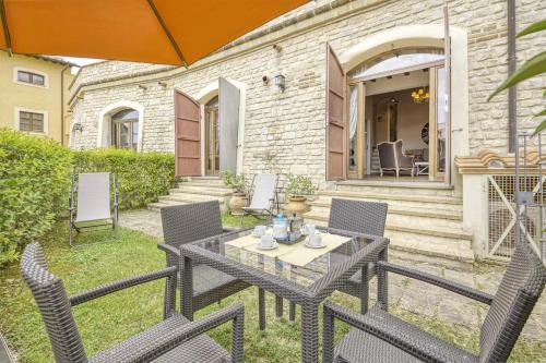 a patio with a table with chairs and an umbrella at Il Conventaccio Luxury Resort in Ficulle