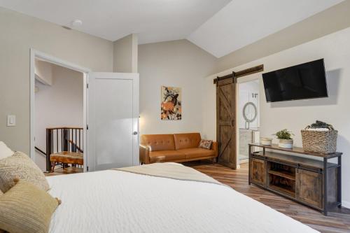 a bedroom with a bed and a flat screen tv at Fox Run Retreat Hot Tub & Fire Pit & BBQ in Colorado Springs