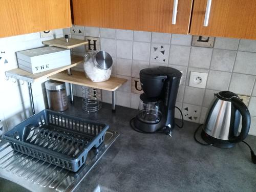 a kitchen with a dish rack in the middle at Le Repaire du Golfeur de la Largue - Mooslargue in Mooslargue
