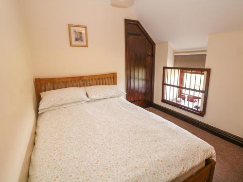 a bedroom with a bed and a window at Downsdale Cottage in Flash