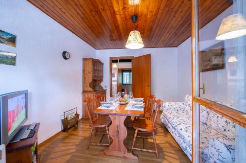 a dining room with a table with chairs and a bed at La Tana dello Scoiattolo Skiing nearby - Happy Rentals in Bardonecchia