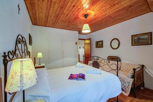 a bedroom with a white bed and a wooden ceiling at La Tana dello Scoiattolo Skiing nearby - Happy Rentals in Bardonecchia