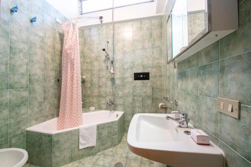a bathroom with a sink and a tub and a toilet at La Tana dello Scoiattolo Skiing nearby - Happy Rentals in Bardonecchia
