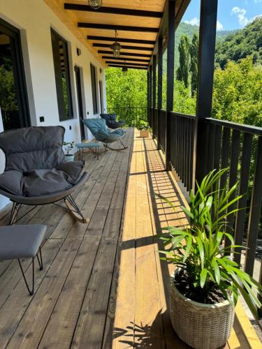 eine Holzveranda mit Stühlen und einer Pflanze darauf in der Unterkunft Debatoun in Debed