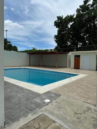 a swimming pool in the middle of a yard at LUXURY APARTAMENTO EN BOCA CHICA cerca Aeropuerto in Santo Domingo