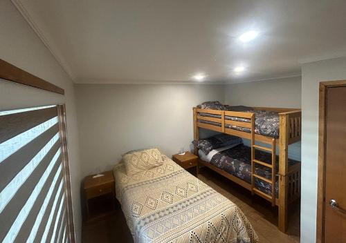 a bedroom with a bed and a bunk bed at Casa Natales- Patagonia House in Puerto Natales