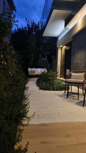 a walkway leading to a building with two benches at La Ginestra C&B House and Rooms in Castel di Sangro
