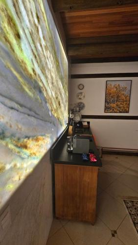 a desk in a room with a painting on the wall at Aldeia Flor de Liz - Pedra Azul in Pedra Azul