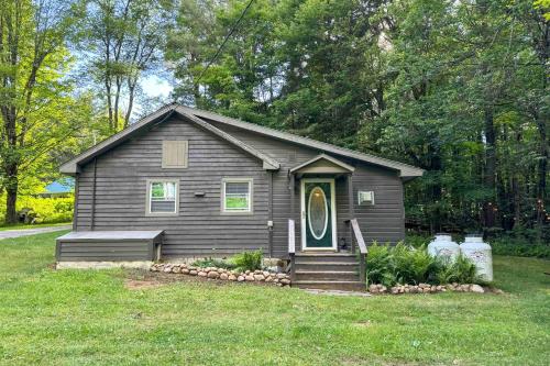 a small house with a green door in a yard at 1 Mi to Brantingham Lake New York Getaway! in Glenfield
