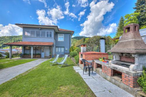 une cour arrière avec une cheminée en briques et une maison dans l'établissement Zio Enry Terrace Apartment Orta Lake - Happy Rentals, à Armeno