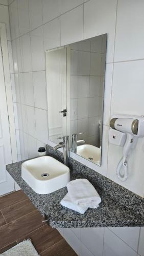 a bathroom with a sink and a mirror at Aldeia Flor de Liz - Pedra Azul in Pedra Azul