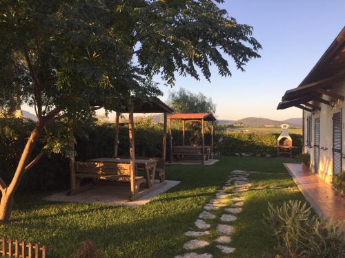 un cortile con panchina e gazebo di Agriturismo Belvedere a Pescia Romana