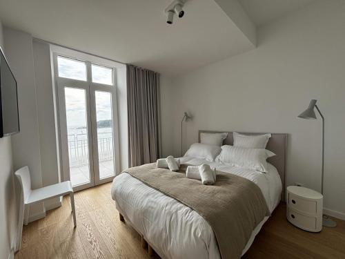 une chambre avec un grand lit avec une grande fenêtre dans l'établissement Beg Leguer T2, trebeurden, à Trébeurden