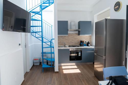 una cocina con una escalera junto a una nevera en Martina's dream, en Villafranca Tirrena