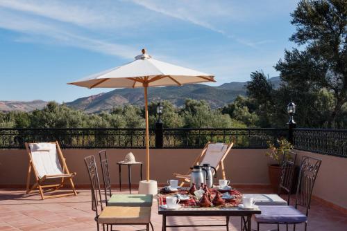 a table and chairs with an umbrella on a patio at Ouirgane Ecolodge in Ouirgane