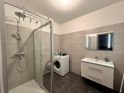 une salle de bain avec douche et machine à laver dans l'établissement Charmant 2 pièce tout équipé climatisé, à Sainte-Lucie de Porto-Vecchio