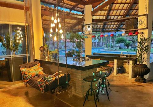 a room with a bar and a table and chairs at Barranko Dus Bakanas in Aruanã