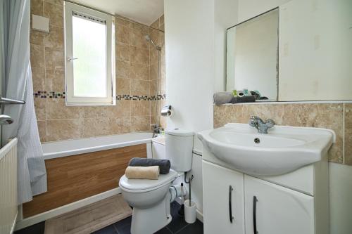 a bathroom with a toilet and a sink and a mirror at MODERN LONDON DOUBLE Bedroom in London