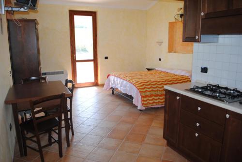a bedroom with a bed and a kitchen with a table at Agriturismo Il Vecchio Carro in Campli