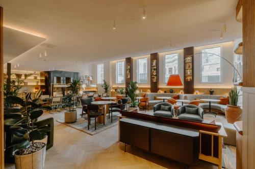 a living room with a lot of furniture and plants at Club Quarters Hotel St Paul's, London in London