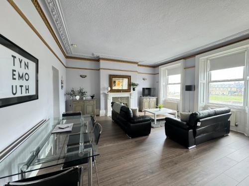 a living room with couches and a table at Longsands Beach, Apartment 2, Tynemouth in Tynemouth