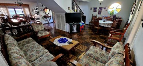 a living room with a couch and a table at Suítes em rua principal de Socorro-SP in Socorro