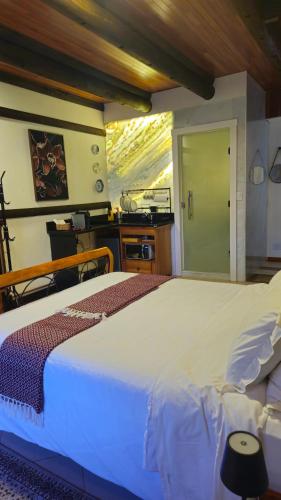 a bedroom with a large white bed in a room at Aldeia Flor de Liz - Pedra Azul in Pedra Azul