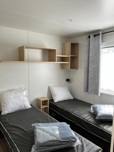 une chambre avec deux lits et une fenêtre dans l'établissement Bungalow cosy à Onzain avec piscine partagée, à Onzain