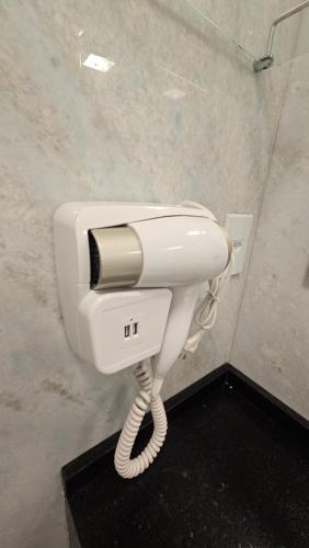 a white phone in a public bathroom stall at Aldeia Flor de Liz - Pedra Azul in Pedra Azul