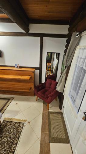 a living room with a red couch and a table at Aldeia Flor de Liz - Pedra Azul in Pedra Azul