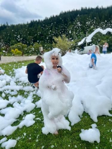 a woman dressed in white standing in the snow at Solny - Resort w Bieszczadach in Cisna