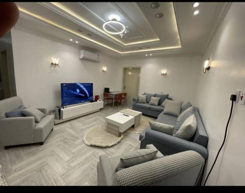 a living room with couches and a flat screen tv at شقة فاخرة بأبها in Abha