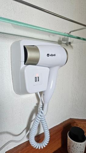 a hair dryer hanging on a wall in a room at Aldeia Flor de Liz - Pedra Azul in Pedra Azul
