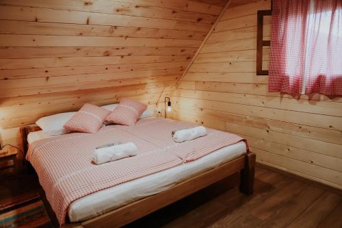 a bedroom with a bed in a wooden cabin at Holiday house Rustic Oak in Gospić