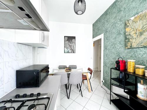 Il comprend une cuisine équipée d'une cuisinière. four supérieur à côté d'une table dans l'établissement Suite Merengue - Check in h24 - Wifi, à Oullins