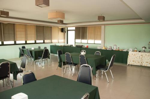 a conference room with green tables and chairs at A Nice Resort in Buriram