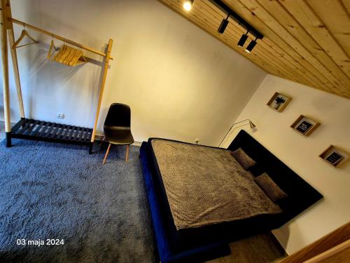 a bedroom with a bed and a chair at Domek nad jeziorem in Skępe